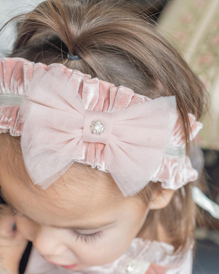 Girl wearing Clara Pink Velour Sash Headband featuring soft blush velour and elegant bow accent.