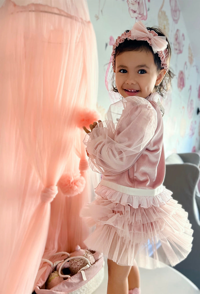 Toddler wearing Clara Pink Velour Sash Headband with ruffled velour band and statement bow detail.