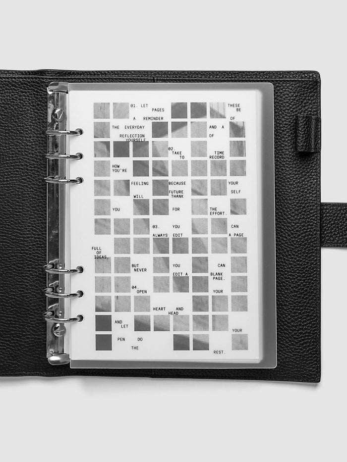 Clear planner cover with black printed text paired with a photographic black and white dashboard. Shown pre-punched for 6-ring planners in the size A5 in a black agenda.