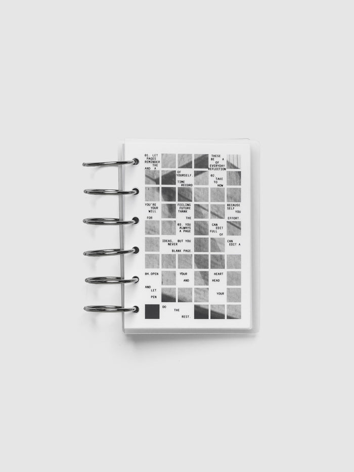 Clear planner cover with black printed text paired with a photographic black and white dashboard. Shown pre-punched for 6-ring planners in the size Pocket.