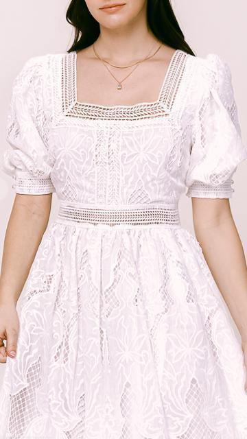 Woman wearing a white puff sleeve square neck broderie anglaise lace maxi dress with intricate floral embroidery